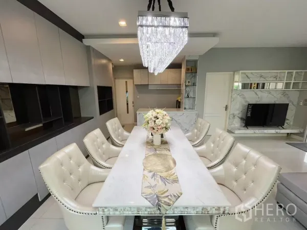 Detached House for rent in Samut Prakan - Elegant dining area with marble-top table, tufted chairs, chandelier, and built-in cabinetry.
