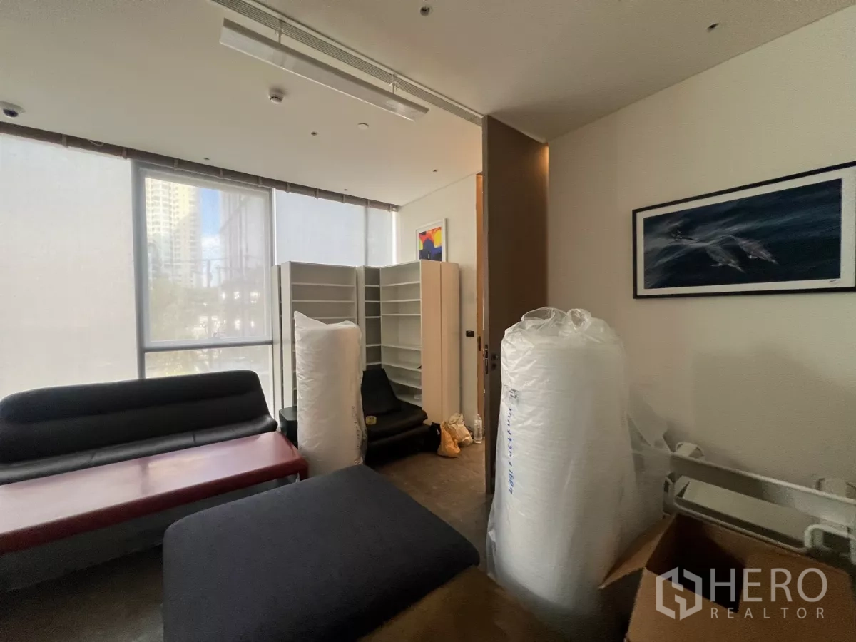 พื้นที่ขายปลีก ให้เช่า - ห้องรองรับงานพร้อมกระจกบานใหญ่ ชั้นเก็บของ และเฟอร์นิเจอร์สำนักงานจัดวางเตรียมฟิตเอาต์.