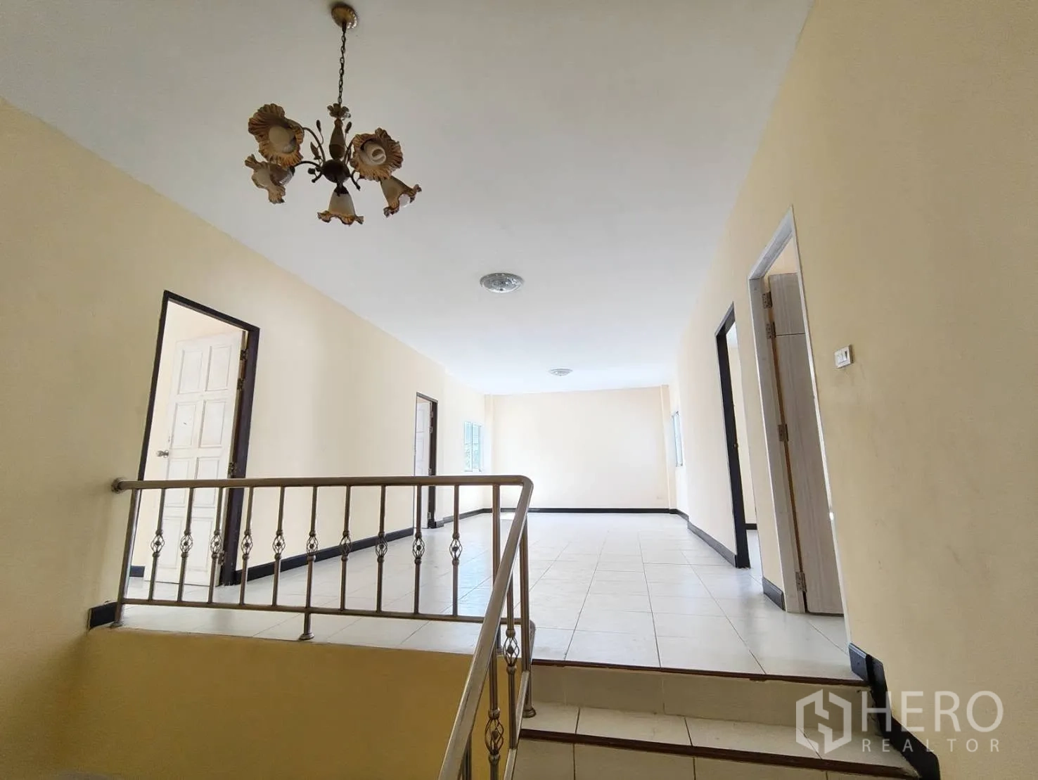 Factory for rent in Krathum Baen, Samut Sakhon - Upstairs corridor with a staircase and decorative chandelier in the house section.