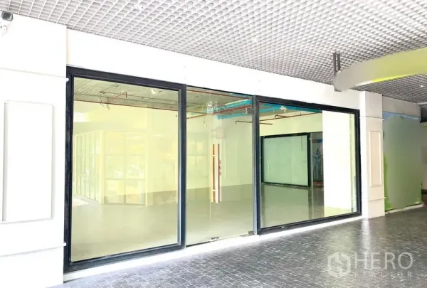 零售空间 出租在Khlong Toei, Bangkok - 黑框大面积玻璃店面，宽幅玻璃入口，位于室内通道。