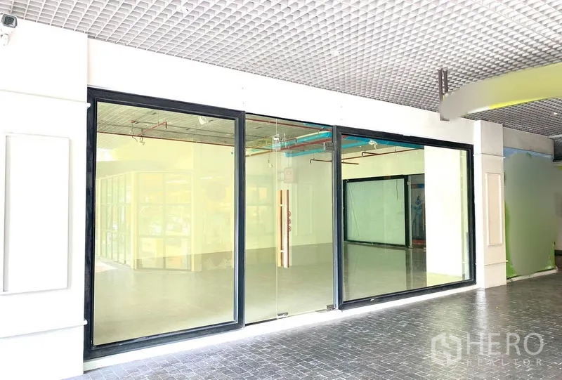 พื้นที่ขายปลีก ให้เช่าในKhlong Toei, Bangkok - หน้าร้านกระจกกรอบสีดำพร้อมประตูกระจกกว้างในโถงอาคาร