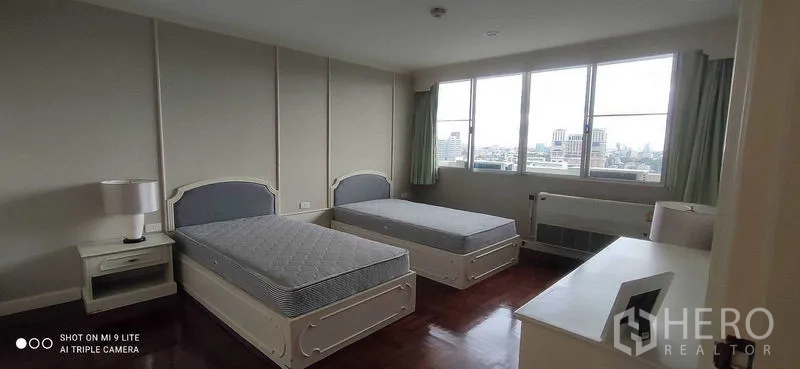 คอนโด ให้เช่าในWatthana, Bangkok - ห้องนอนเตียงเดี่ยวสองเตียง โต๊ะข้างเตียง หน้าต่างบานกว้างเห็นสกายไลน์