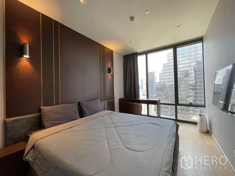Condominium for rent in Bang Rak, Bangkok - Master bedroom with feature wall, king bed, large windows and skyline outlook.