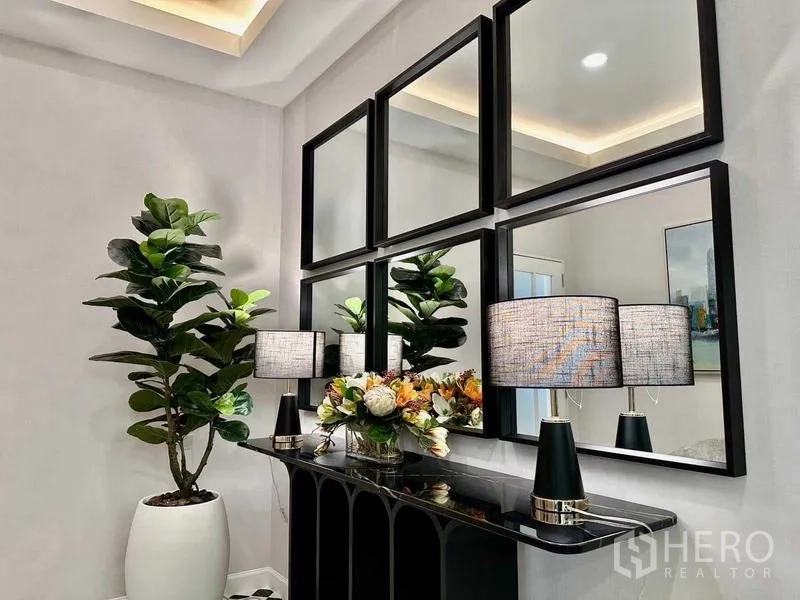 Detached House for rent in Bang Phli, Samut Prakan - Decorative console with framed mirrors, table lamps and indoor plant.