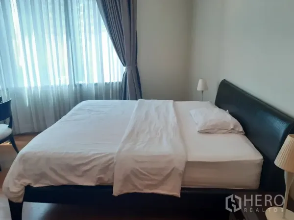 คอนโด ให้เช่าในKhlong Toei, Bangkok - ห้องนอนหลัก เตียงขนาดใหญ่ โคมไฟหัวเตียง และหน้าต่างกว้างพร้อมผ้าม่านรับแสงธรรมชาติ