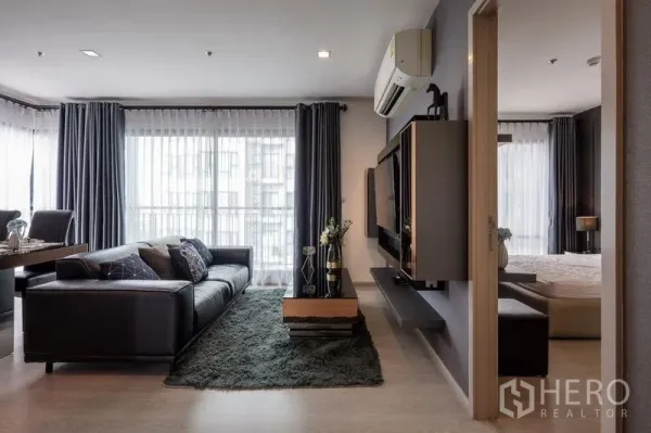 公寓 出租或出售在Khlong Toei, Bangkok - 客厅设壁挂电视与地毯，旁为通往卧室的门。