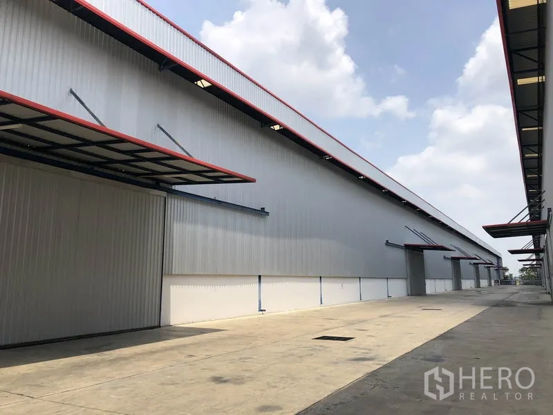 โรงงาน ให้เช่าหรือขายในPhra Nakhon Si Ayutthaya - ด้านข้างโกดังยาว มีกันสาดคลุมจุดโหลดสินค้าและพื้นที่เข้าถึงสะดวก