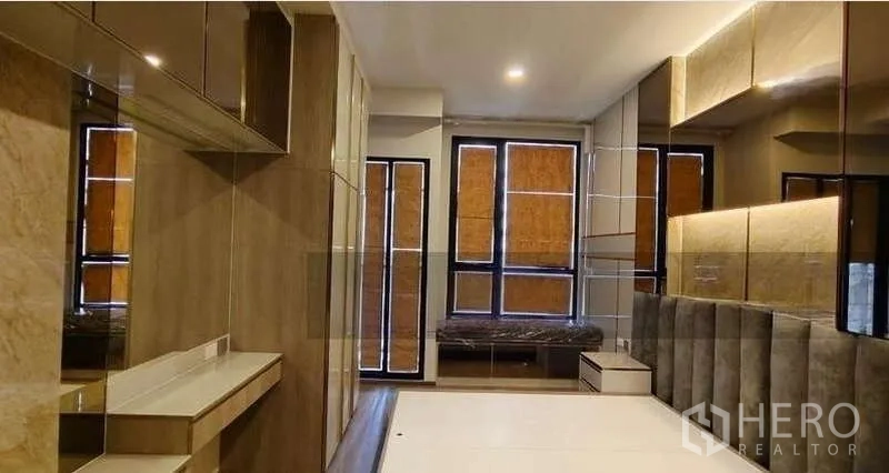 Condominium for sale - Contemporary bedroom with built-in cabinetry, mirrored walls and a window seat in a Bangkok condo near BTS Phaya Thai.