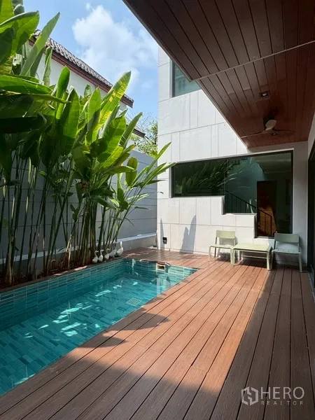 Semi-detached House for rent in Watthana, Bangkok - Private plunge pool with timber deck, tropical plants, and lounge chairs.