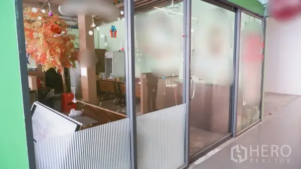 零售空间 出租在Watthana, Bangkok - 店铺外立面为落地玻璃，可从走廊看到室内座位区。