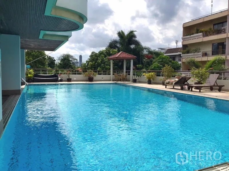 คอนโด ให้เช่าในKhlong Toei, Bangkok - สระว่ายน้ำกลางแจ้งขนาดใหญ่ ล้อมด้วยต้นไม้และเตียงอาบแดด