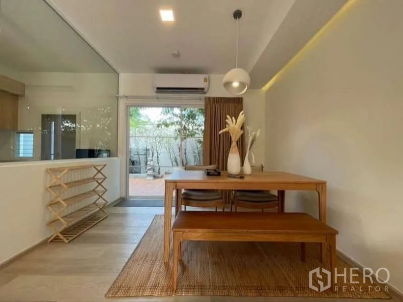 ทาวน์เฮาส์ ให้เช่าในPrawet, Bangkok - โซนรับประทานอาหาร โต๊ะไม้ โคมแขวน และประตูเลื่อนไปชานบ้าน