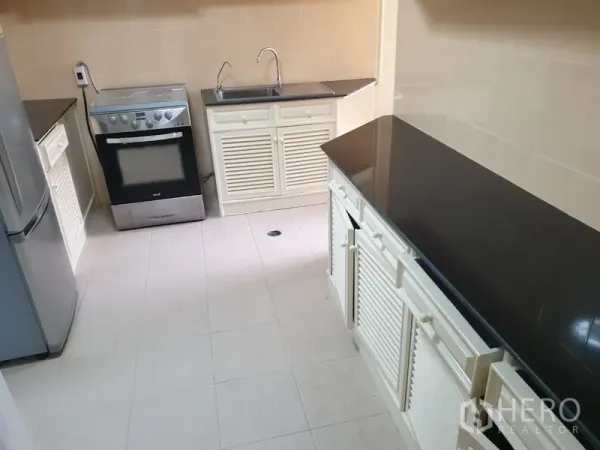 คอนโด ให้เช่าในWatthana, Bangkok - ครัวปิด เคาน์เตอร์หินสีดำ ตู้บานเกล็ด ตู้เย็น เตาอบ และอ่างล้างจาน