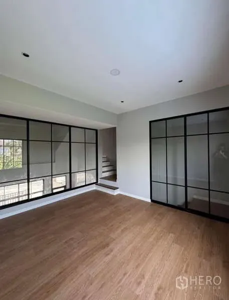 联排别墅 出租或出售在Prawet, Bangkok - 木地板房间，整面黑框落地窗