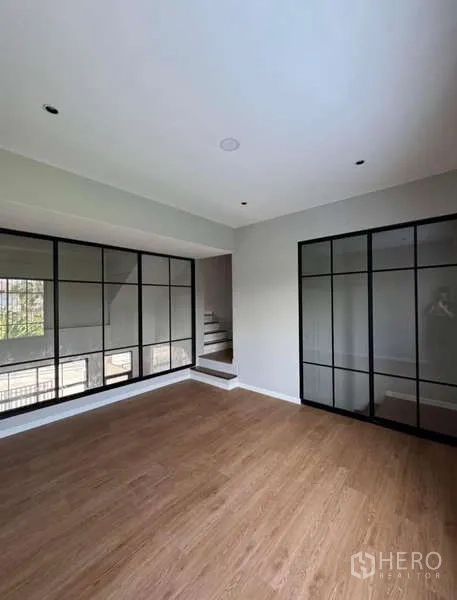 联排别墅 出租或出售在Prawet, Bangkok - 木地板房间，整面黑框落地窗