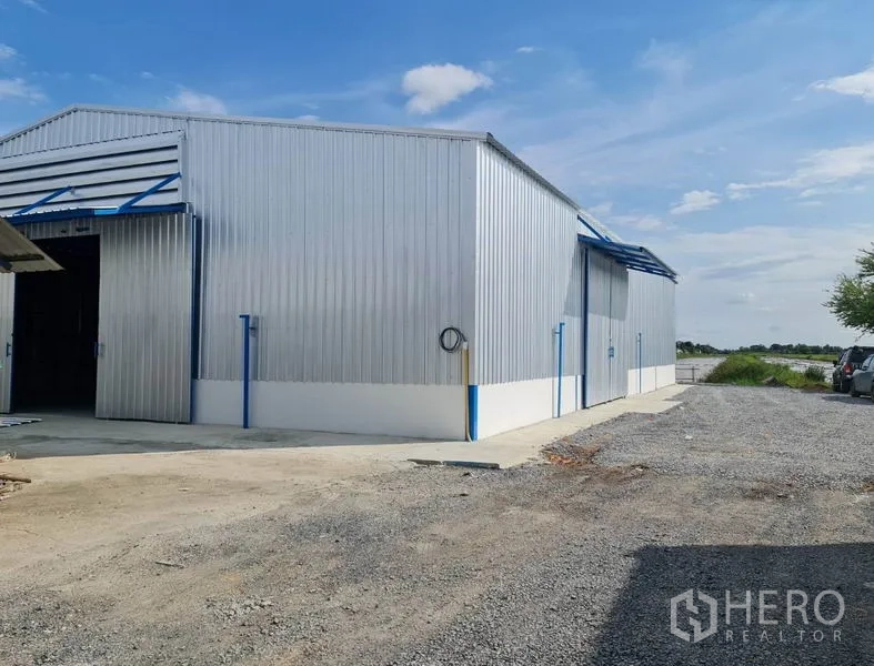 คลังสินค้า ให้เช่าในNong Chok, Bangkok - ภายนอกโกดังผนังเมทัลชีท ประตูบานเลื่อน และลานโรยหิน ที่หนองจอก กรุงเทพฯ