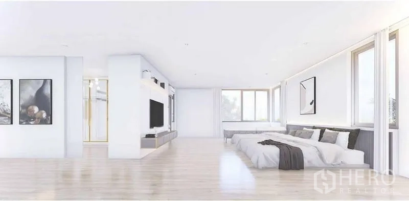 独立式住宅 出租在Lat Phrao, Bangkok - 大型明亮卧室，平台床、电视墙、宽窗与浅色木地板。