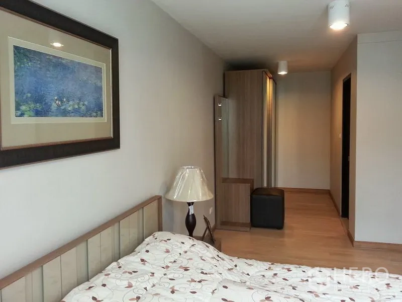 คอนโด ให้เช่าหรือขายในChatuchak, Bangkok - ทางเดินในห้องนอน พร้อมภาพติดผนัง ตู้เสื้อผ้ามีกระจก และโคมไฟตั้งพื้น