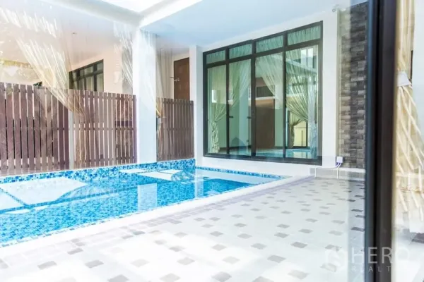 Detached House for rent in Khlong Toei, Bangkok - Private courtyard swimming pool with blue mosaic tiles beside floor-to-ceiling glass doors.