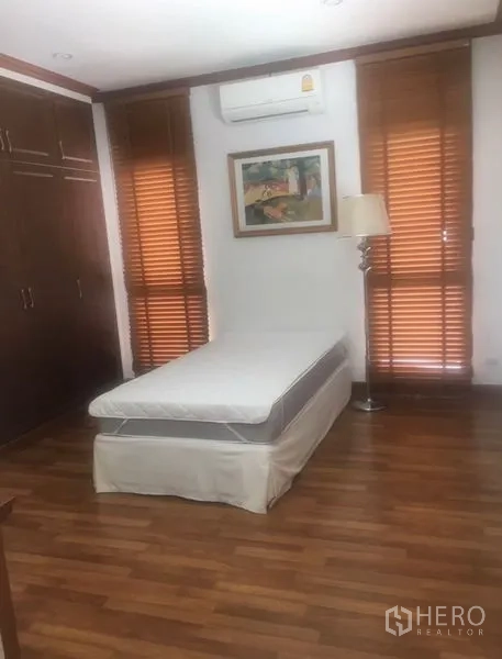 Detached House for sale in Saphan Sung, Bangkok - Cozy bedroom with single bed, built-in wardrobes, wooden blinds and air conditioning.
