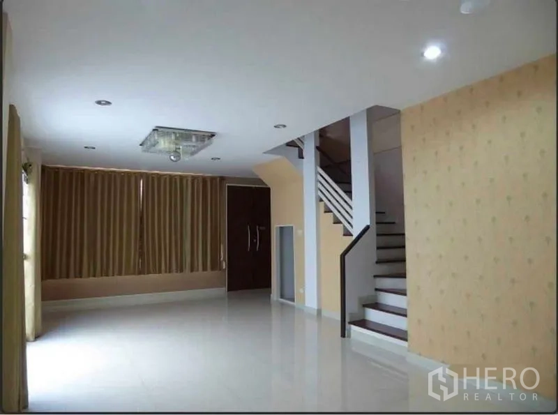 Home Office for rent in Bueng Kum, Bangkok - Spacious ground-floor living area with glossy tile floors, recessed lights and a staircase.