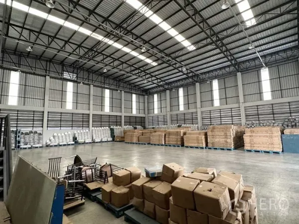 货栈 出租在Bang Phli, Samut Prakan - 开阔仓储区，带高窗与金属板墙，货物整齐堆放在托盘上。