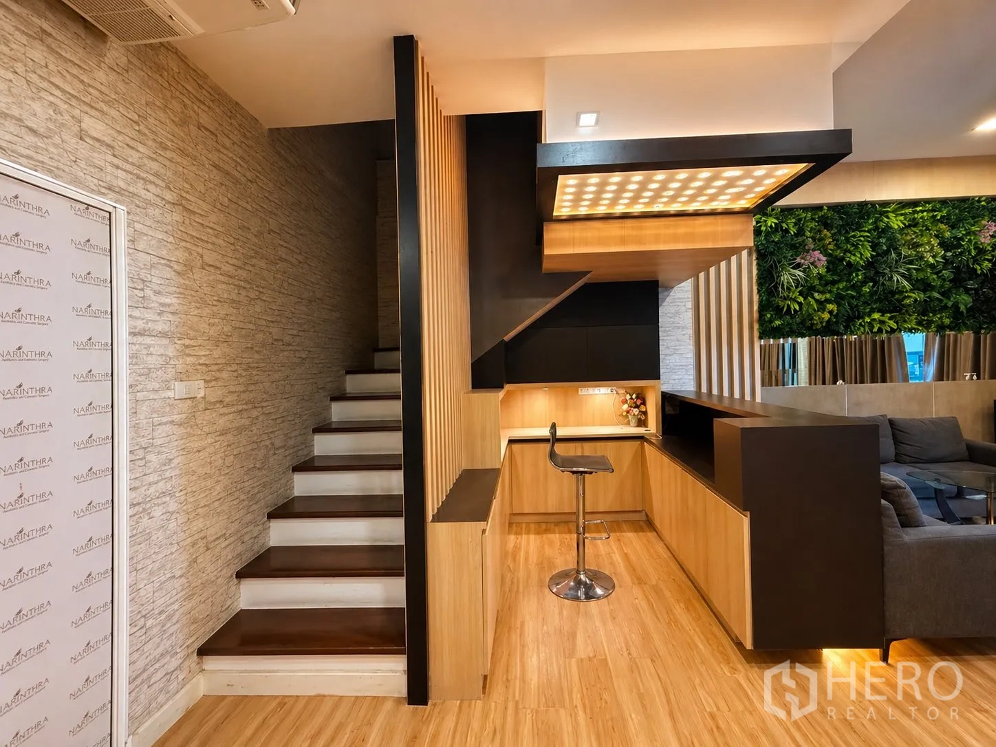 Home Office for rent or sale in Yan Nawa, Bangkok - Wood-trimmed staircase and built-in counter with spotlight ceiling and a bar stool.