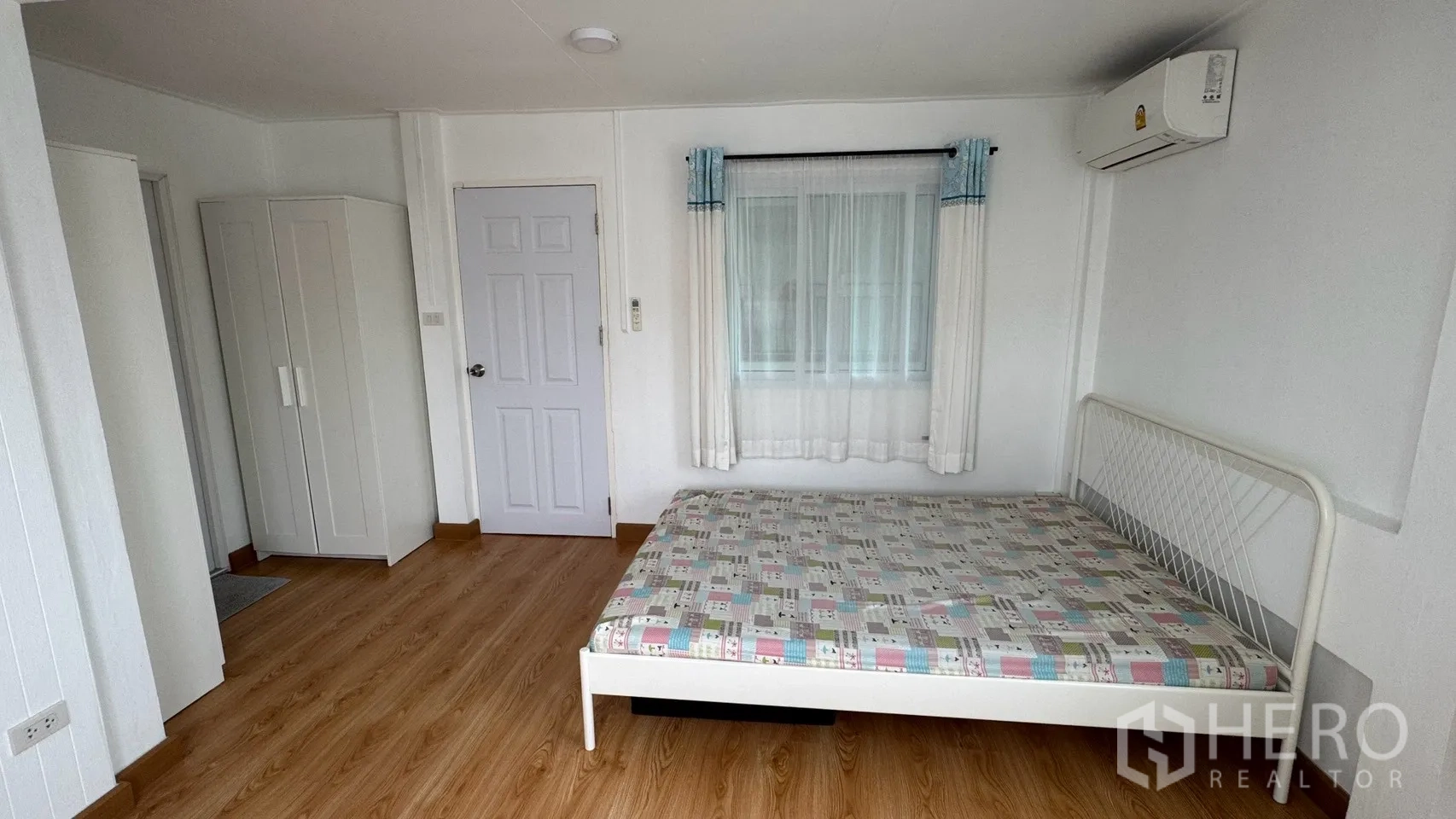 Detached House for rent in Saphan Sung, Bangkok - Simple bedroom with a white bed frame, wardrobe, sheer curtains, and air conditioning.
