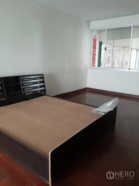 零售空间 出租在Watthana, Bangkok - 宽敞房间，木地板，靠窗摆放平台床架。