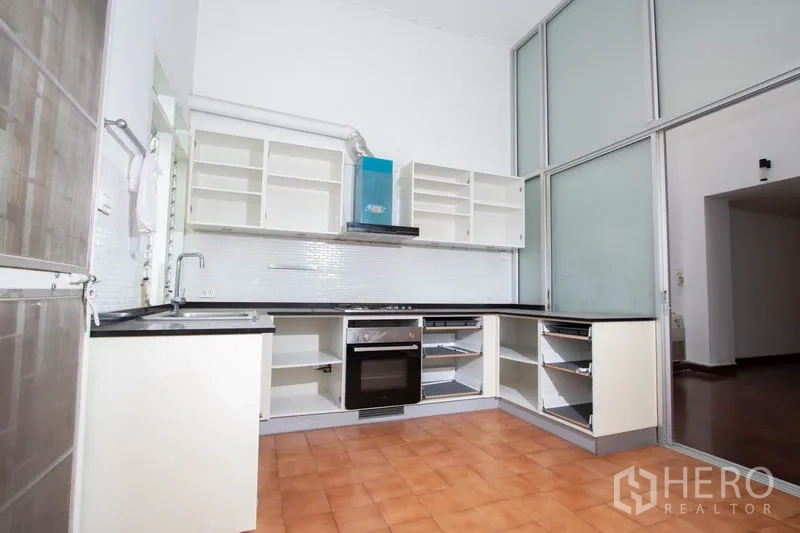 ทาวน์เฮาส์ ให้เช่าในKhlong Toei, Bangkok - ห้องครัวรูปตัวแอลสว่าง ตู้บิวท์อิน เตาอบ และผนังกระจกฝ้า