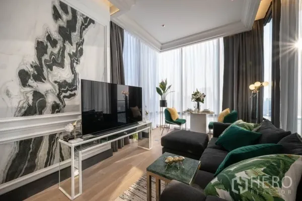 Condominium for rent in Bang Rak, Bangkok - Bright Silom condo living area with marble feature wall, floor-to-ceiling windows, plush sofa and TV.