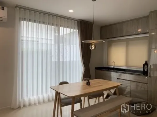 บ้าน ให้เช่าในBang Kapi, Bangkok - มุมรับประทานอาหารสว่างไสว โคมไฟแขวน และตู้แพนทรีบิวท์อินพร้อมผ้าม่านโปร่ง