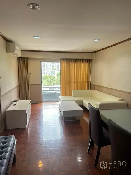 คอนโด ให้เช่าในWatthana, Bangkok - ห้องนั่งเล่นสว่าง โซฟาเข้ามุม โต๊ะกลาง และระเบียงเห็นวิวเมืองในคอนโดย่านสุขุมวิท