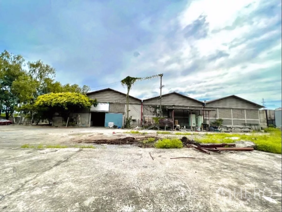 工厂 出租在Sai Noi, Nonthaburi - 工厂正立面与开阔装卸场地，周边有绿化。