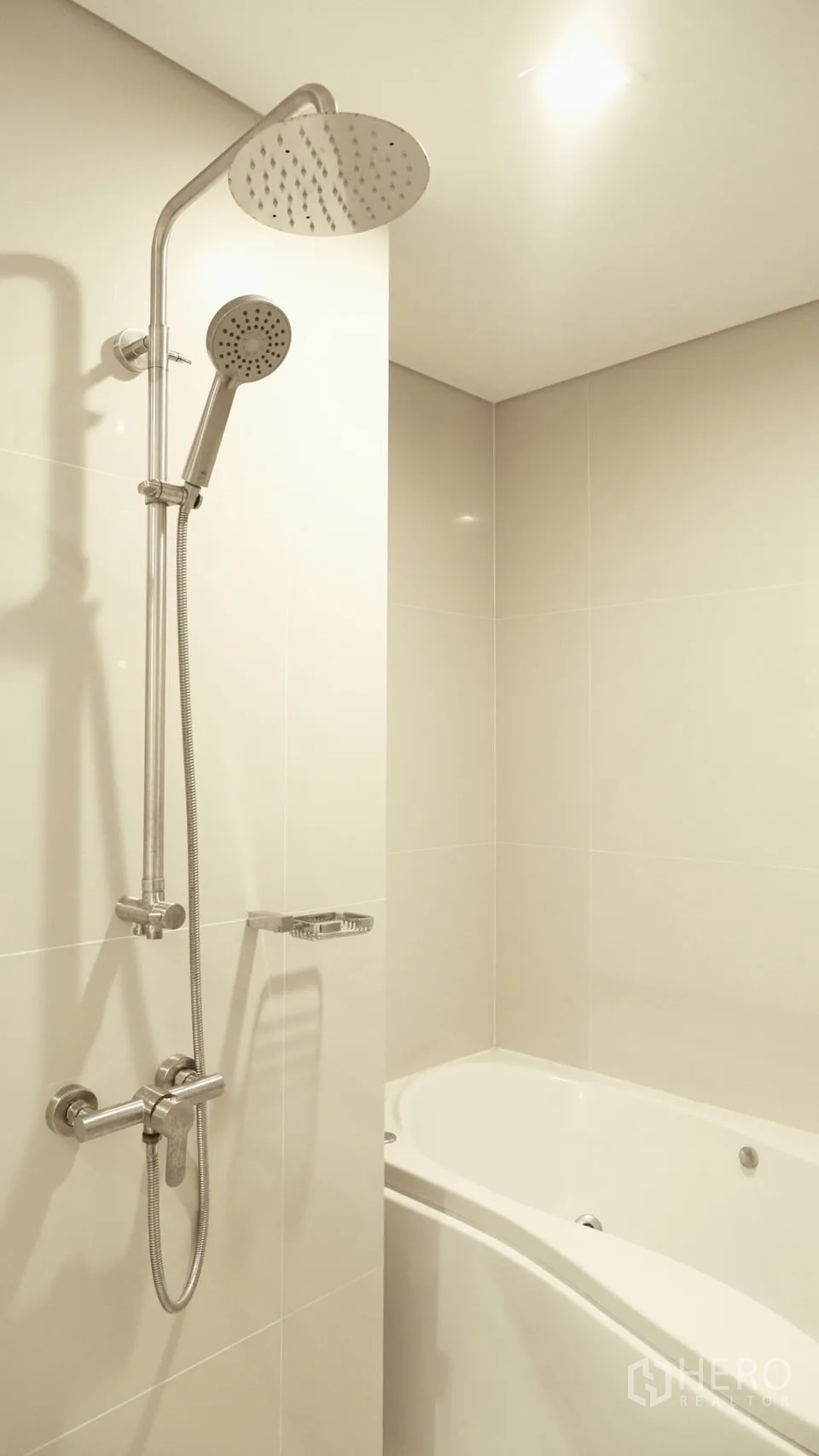 Condominium for rent in Watthana, Bangkok - Bathroom with rain shower and handheld shower above a soaking bathtub.