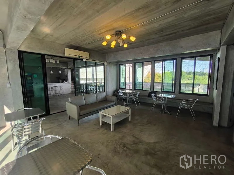 Warehouse for rent in Huai Khwang, Bangkok - Another angle of the lounge showing large windows and sliding glass doors.