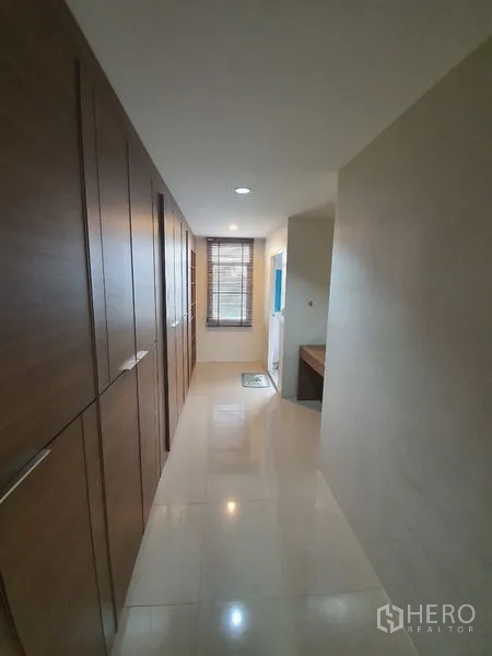 Townhouse for rent in Phaya Thai, Bangkok - Upper-floor corridor with full-height wardrobes, window and glossy tile flooring.