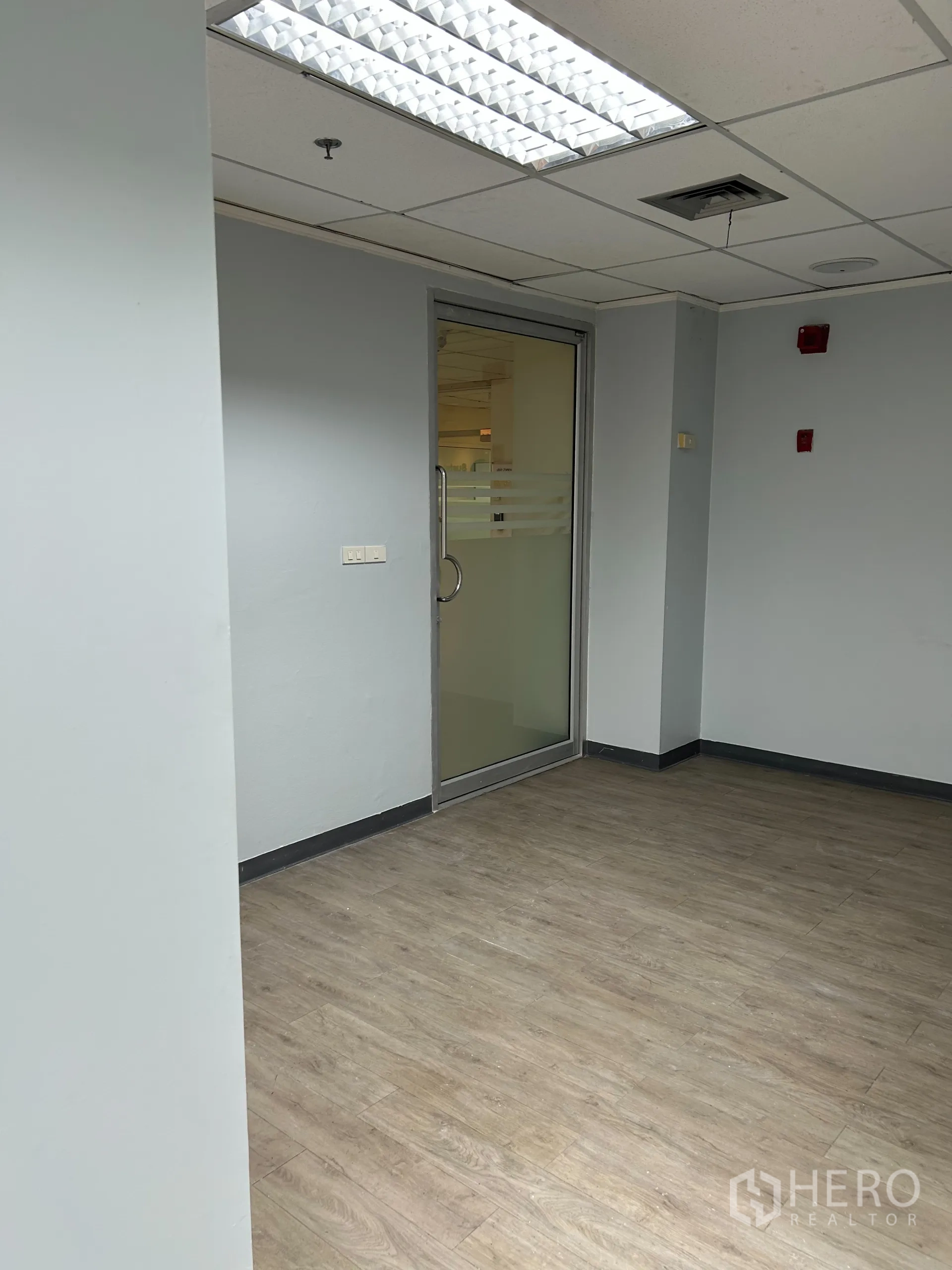 办公空间 出租在Khlong Toei, Bangkok - 小型接待区，玻璃入户门，格栅天花与荧光灯。