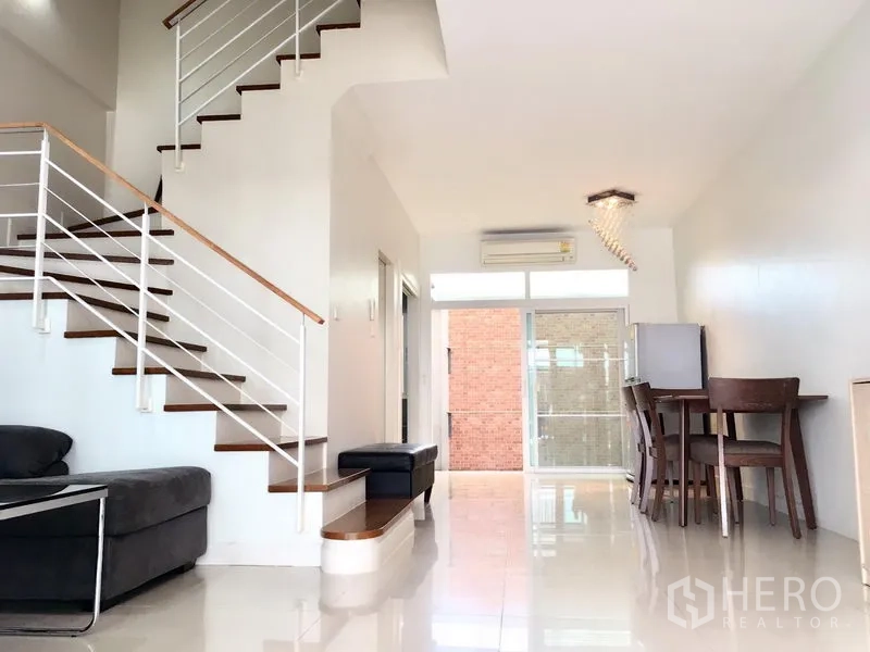 ทาวน์เฮาส์ ให้เช่าในPrawet, Bangkok - พื้นที่นั่งเล่นและรับประทานอาหารแบบเปิดโล่ง พื้นเงาและบันไดไม้.