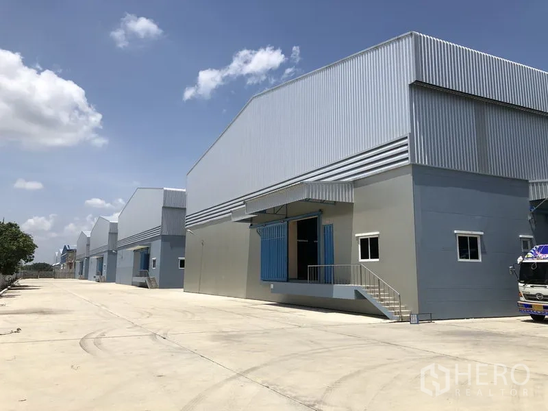 Warehouse for rent in Lat Lum Kaeo, Pathum Thani - Row of new warehouses along a spacious driveway designed for large vehicle circulation.