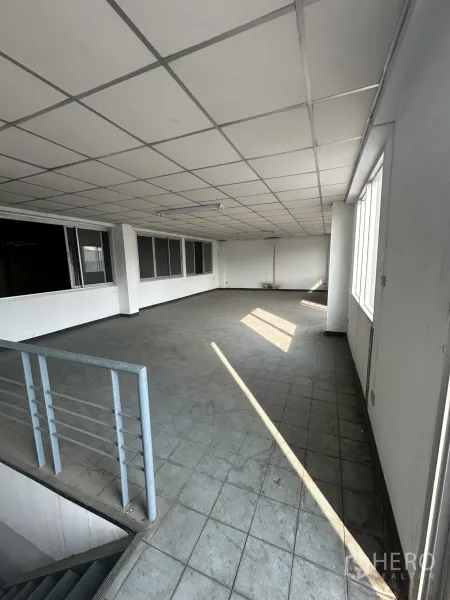 Factory for rent or sale in Khlong Luang, Pathum Thani - Open mezzanine level with stair railing, tiled floor and ceiling lights for flexible workspace.