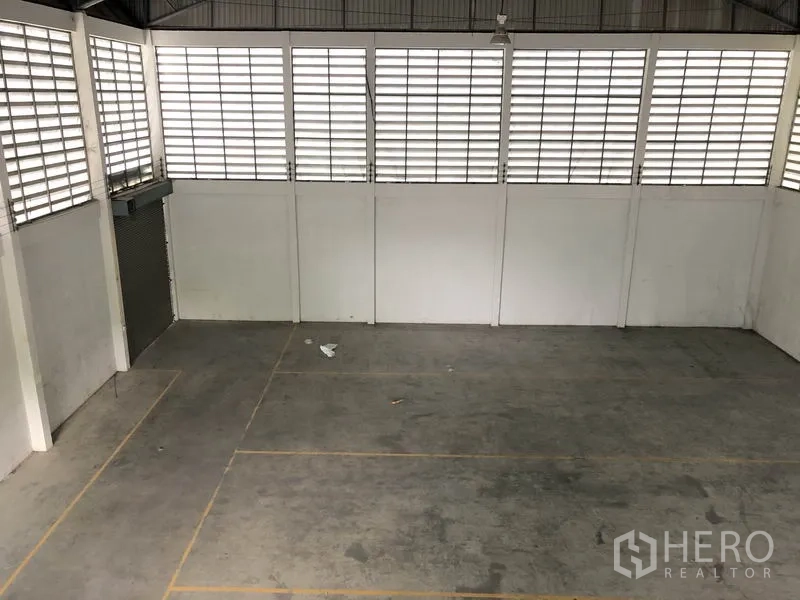 货栈 出租或出售在Lam Luk Ka, Pathum Thani - 开阔库区地面，划线分区，侧边卷帘门便于装卸。