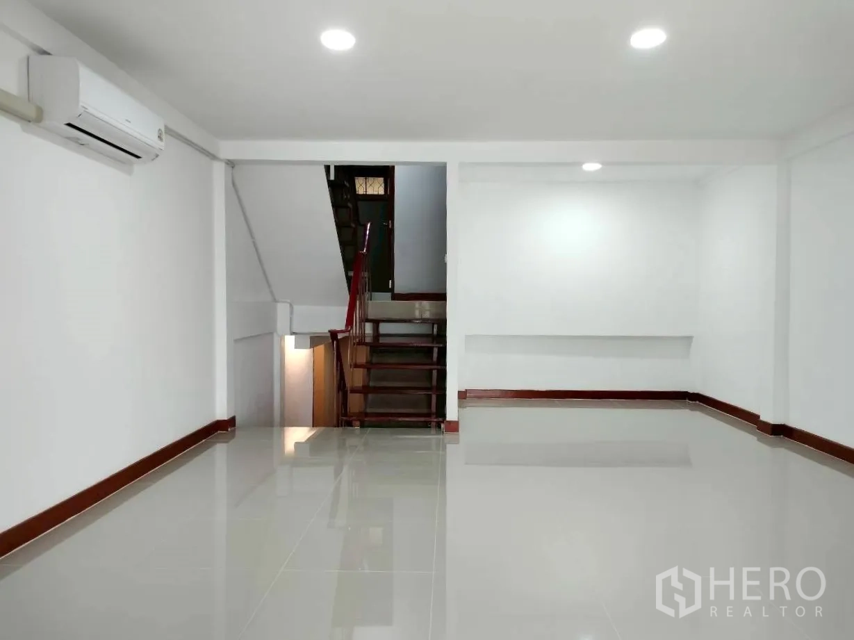 Home Office for rent in Watthana, Bangkok - Open lower-level space with air conditioner and internal staircase.