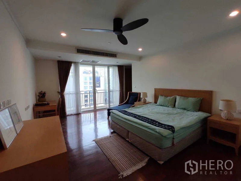 公寓 出租在Khlong Toei, Bangkok - 卧室配特大床与吊扇，推拉门通往观景阳台。