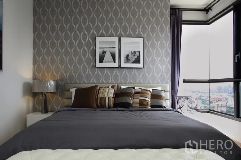 คอนโด ให้เช่าหรือขายในWatthana, Bangkok - ห้องนอนหลักมีผนังลายกราฟิก หน้าต่างมุมห้อง และวิวสกายไลน์กว้าง