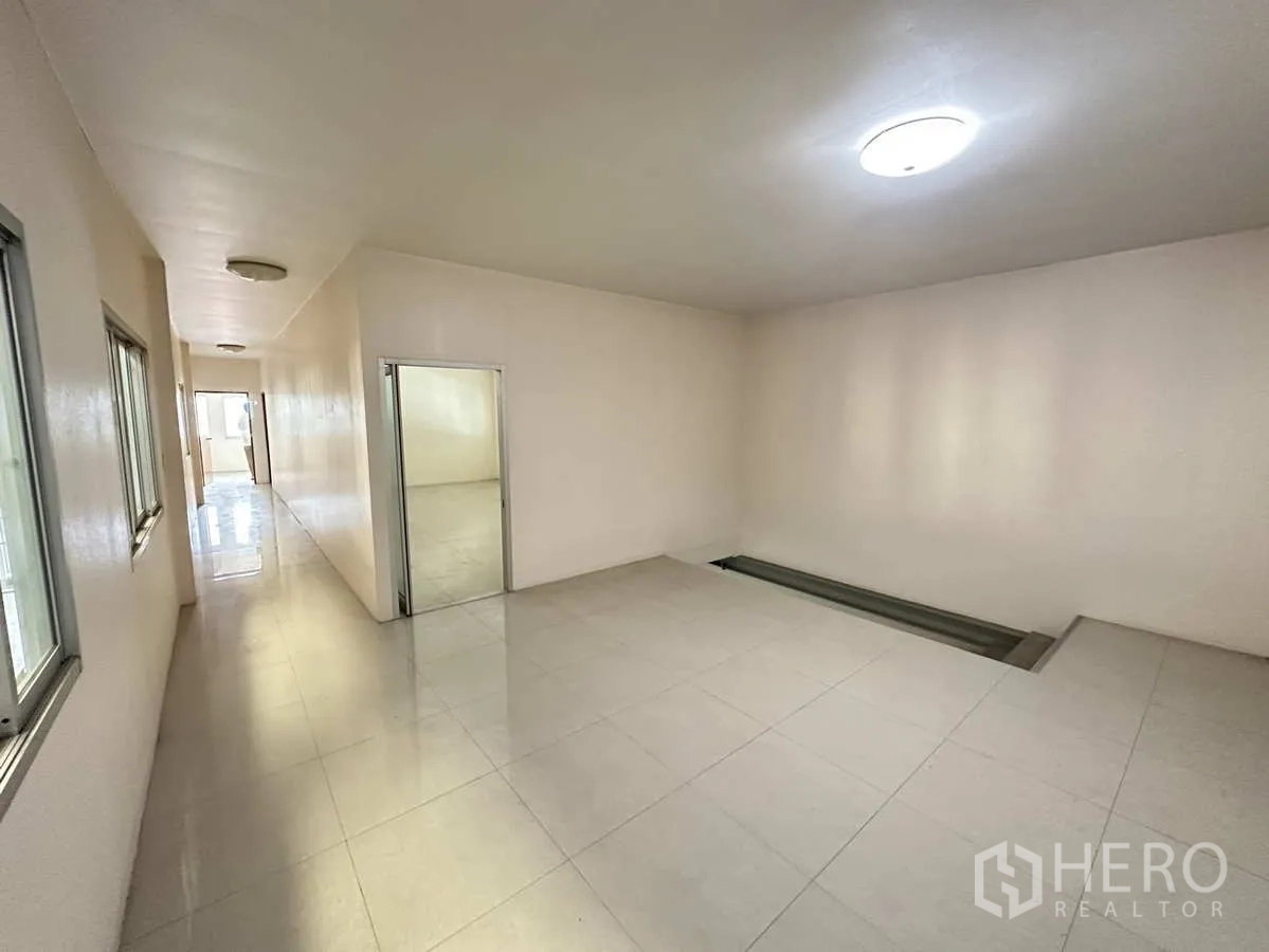 Factory for rent in Pathum Thani - Clean corridor inside the office building with private rooms and glossy floor tiles.