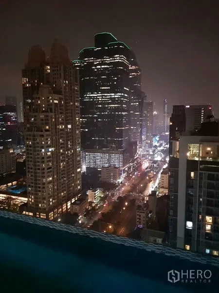 Condominium for rent in Sathon, Bangkok - Night view of Bangkok skyline and illuminated avenue from the rooftop pool edge.