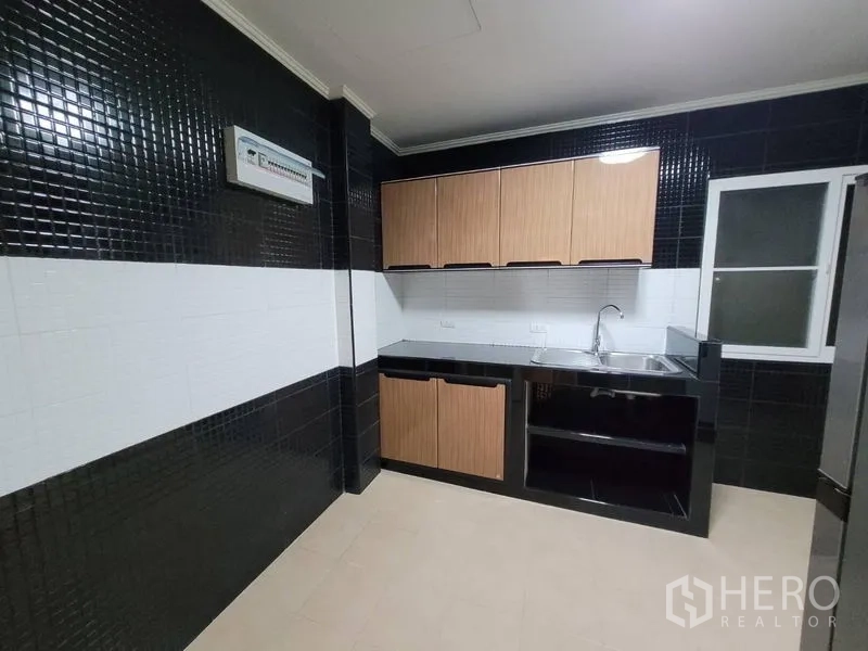 บ้าน ให้เช่า - ห้องครัวบิวท์อิน ผนังกระเบื้องขาวดำ ตู้ไม้ และอ่างล้างจานสเตนเลส