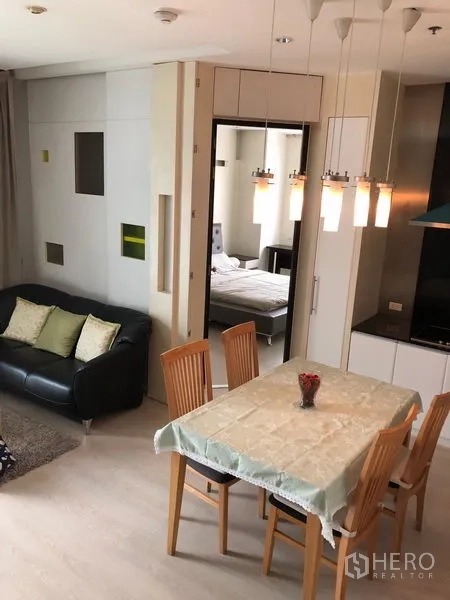 公寓 出租在Khlong Toei, Bangkok - 餐厅与开放式厨房相连，四人餐桌及吊灯，旁有通往卧室的门。