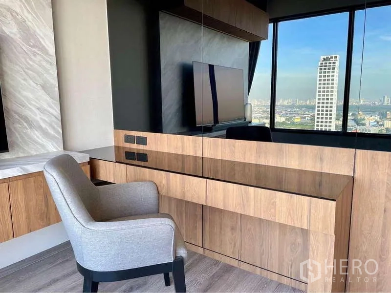 公寓 出租在Watthana, Bangkok - 书写区设软包椅与长木桌，对面为镜面墙并可眺望城市景观。